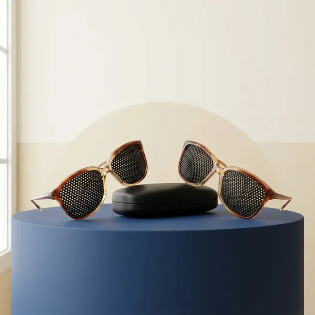 Pack Duo Ophtalgym : deux paires de lunettes à trous et un étui sur un socle bleu encre